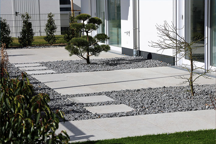 Design moderno della terrazza con cemento, pietra e piante
